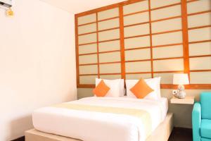 塞米亚克水明漾苹果别墅及套房酒店的卧室配有带橙色枕头的大型白色床