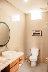 塞米亚克水明漾苹果别墅及套房酒店的一间带卫生间、水槽和镜子的浴室