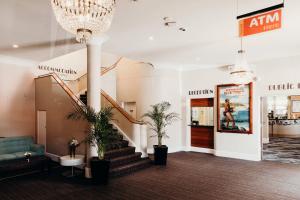 麦夸里港麦夸里港口酒店的大堂设有楼梯和盆栽植物