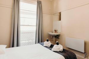 麦夸里港麦夸里港口酒店的一间卧室配有床、水槽和镜子