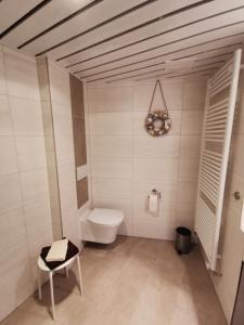 克隆斯加尔德Ferienwohnungen Traumlage的一间带卫生间和椅子的浴室
