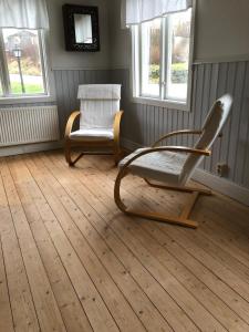 乌拉勒德Hagabergets Vandrarhem的一间设有两把椅子和两扇窗户的房间