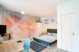 锡比乌Galeria Grafit Apartments的一间卧室配有一张带彩色墙壁的床