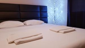 多布拉沃达Monte Liza的一张白色的床,上面有两张折叠毛巾