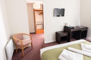 凯里肯肯兹艾姆酒店 - “订制酒店”的酒店客房配有一张床、一把椅子和一台电视。