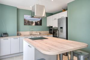 雷岛林滩Maison Les Burons的厨房配有白色橱柜和木制台面