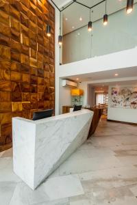 瓜达拉哈拉FCH Hotel Providencia的大堂设有大理石柜台和石墙