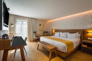 瓜达拉哈拉FCH Hotel Providencia的酒店客房设有一张大床和一张书桌。