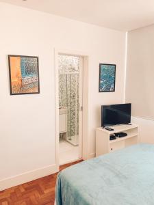 里约热内卢Stylish Copacabana Apartment的一间卧室设有一张床、一台电视和一个窗口。