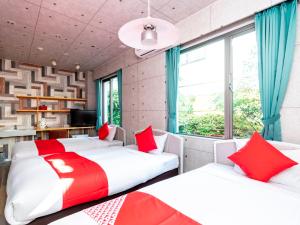 唐津飞鸟酒店 的红色和白色的客房内的两张床