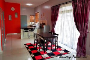 峇株巴辖Pesona Suri Homestay的用餐室以及带红色墙壁和桌子的厨房