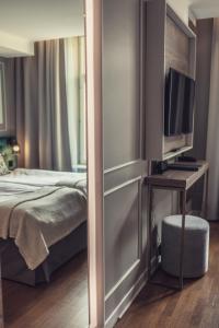 哥德堡波塞顿酒店的一间卧室配有一张床和一张书桌及电视