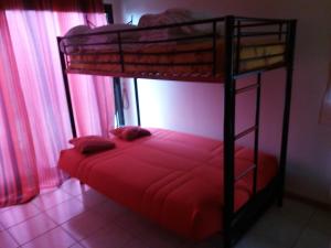 保拉扎克Chambres chez l'habitant Coco2的一间卧室配有两张双层床,铺有红色床单