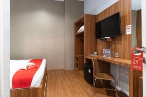 棉兰RedDoorz Premium near Centre Point Mall Medan的一间酒店客房,配有一张床和一台电视