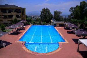 基加利诺布莱扎酒店的一个带椅子和遮阳伞的游泳池
