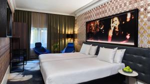 阿姆斯特丹Clayton Hotel Amsterdam American的一间酒店客房,设有两张床和电视