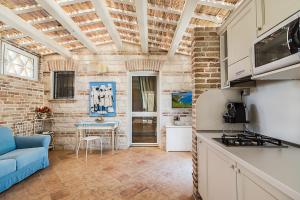 锡罗洛Il Casale Di Giulia的厨房配有蓝色的沙发和桌子