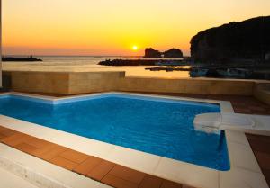白滨Daikyo Engtsuto Villa的一座享有日落美景的游泳池