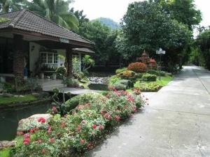 Ban Nong Saeng (4)จักรดาว เมาท์เท่น วิว (Mountain View)的一座花园,在房子前种有鲜花