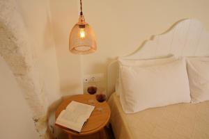 罗希姆诺Veranda Rossa Suites的一间卧室配有一张床和一张桌子及一本书