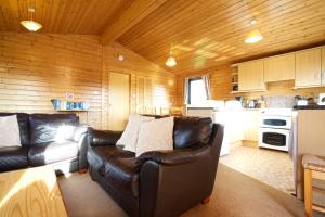 克里夫Concraig Lodge的一间带真皮沙发的客厅和一间厨房