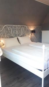 克罗夫Der Weinladen的白色的床,配有金属床头板和白色枕头