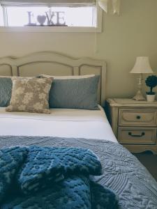 WinghamLittle Britton的一间卧室配有一张带蓝色毯子和床头柜的床