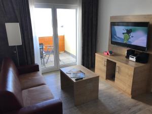 费尔德伯格Ferienwohnung Gipfelstürmer Feldberg - Ski in Ski out, Whirlpool & Infrarotkabine的带沙发和平面电视的客厅