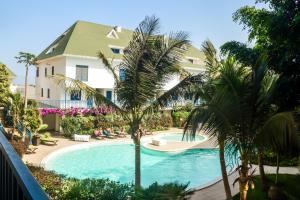 圣玛丽亚雷米贝济公寓式酒店的棕榈树建筑前的游泳池
