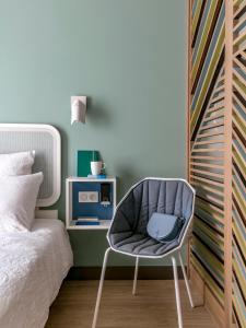 土伦OKKO Hotels Toulon Centre的卧室配有床边的椅子