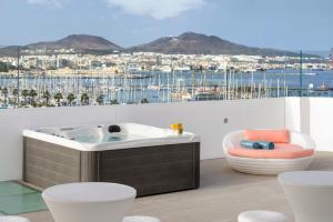 大加那利岛拉斯帕尔马斯Occidental Las Palmas的阳台上设有热水浴缸,享有海港景色