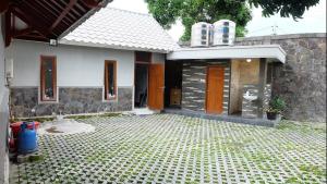 日惹Omah Dronjongan Homestay Yogyakarta的前面设有瓷砖庭院的房子