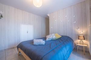 FrancinLa Savouè - Chambre的一间卧室配有一张蓝色床单,墙上有鸟儿