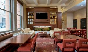 巴尔的摩巴尔的摩驻桥套房假日酒店 - 内港的一间带桌椅和壁炉的餐厅