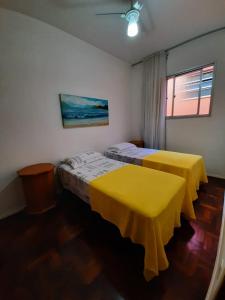 维拉维尔哈Yellow Hostel Praia da Costa的配有黄色床单的客房内的两张床