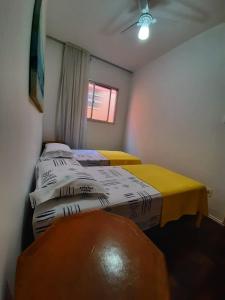 维拉维尔哈Yellow Hostel Praia da Costa的带窗户的客房内设有两张单人床。
