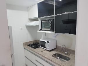 戈亚尼亚Flat mobiliado em região nobre de Goiânia的厨房配有微波炉和水槽