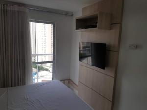 戈亚尼亚Flat mobiliado em região nobre de Goiânia的一间卧室设有一张床和一个大窗户