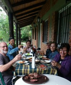 圣奥古斯汀镇posada cerro los nogales的一群坐在餐桌上吃食物的人
