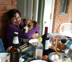圣奥古斯汀镇posada cerro los nogales的一只狗在桌子上 ⁇ 着的女人