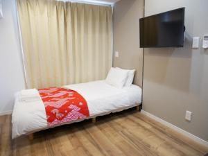 东京Tokyo shinjukutei Hotel Asahi gruop 東京新宿亭ホテル的一间小卧室,配有一张床和一台平面电视