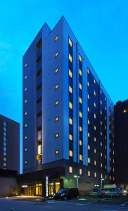 宇都宫Smile Hotel Utsunomiya Nishiguchi Ekimae的停车场内有窗户的大型建筑