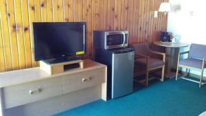 BridgeportMeadow Park on 385的客厅配有电视和带椅子的桌子