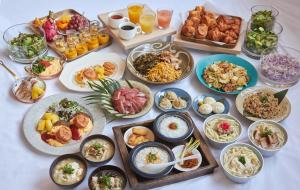 北谷町Lequ Okinawa Chatan Spa ＆ Resort的一张桌子上放着许多盘子的食物