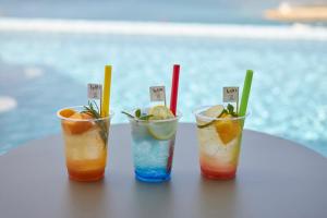 北谷町Lequ Okinawa Chatan Spa ＆ Resort的坐在桌子上的三杯鸡尾酒