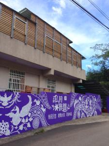 尖石乡水田私房农园的一座带紫色墙和画的建筑