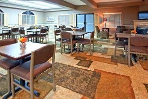 伊根Norwood Inn & Suites Eagan St Paul & Mall of America的一间在房间内配有桌椅的餐厅