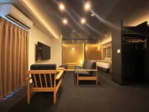 福冈Randor Residential Hotel Fukuoka Annex的酒店客房,配有一张床和两把椅子