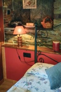 塔拉蒙迪Esquíos - Apto. El Pajar的一间卧室配有一张床和一张桌子上的台灯