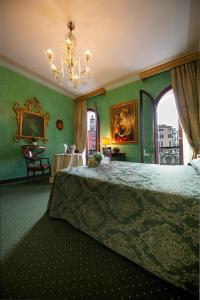 威尼斯马可尼酒店的一间卧室设有绿色的墙壁和一张带吊灯的床。